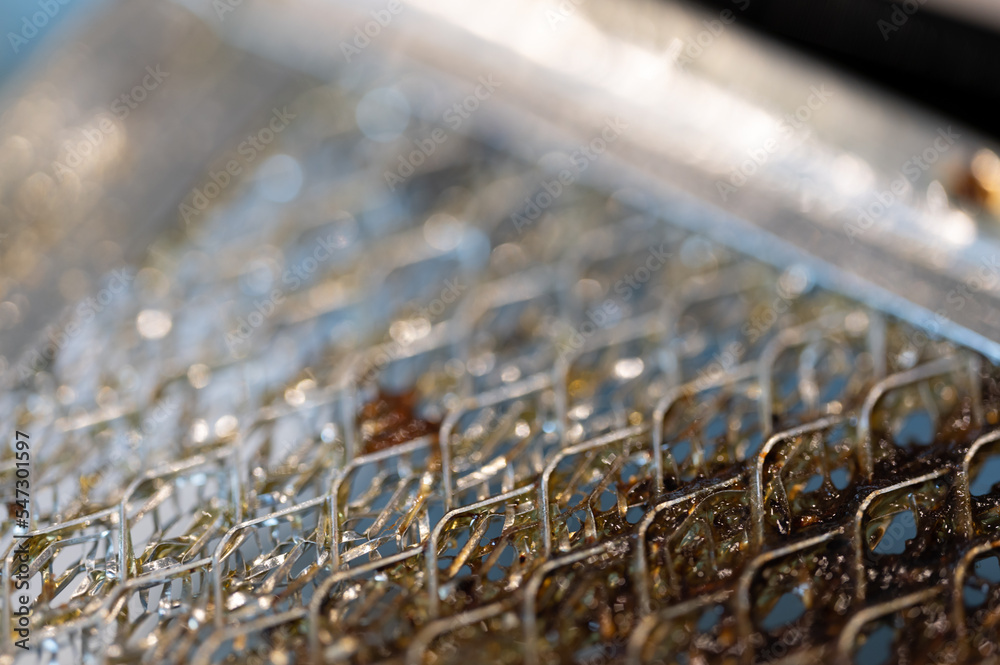 Fototapeta premium Selective focus macro of a dirty kitchen range hood filter clogged with grease.