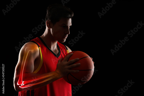 Digital composite of highlighted bones and basketball player with ball on black background