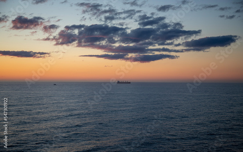 A lone ship in the distance during a sunset