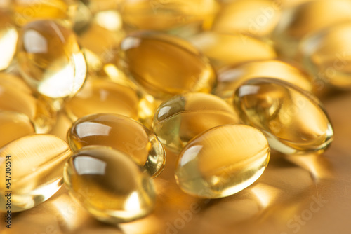 Vitamin E Supplementary food. Omega 3. Gold fish oil gel Capsules background.
