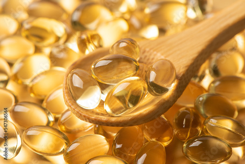 Vitamin E Supplementary food. Omega 3. Gold fish oil gel Capsules background.