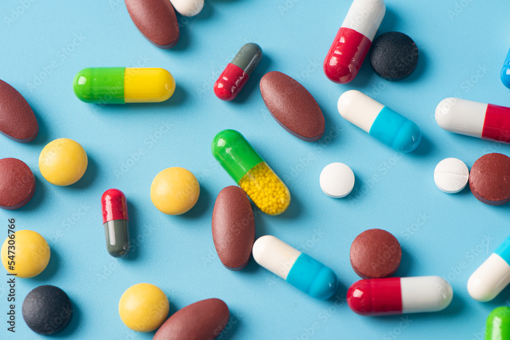 multicolored pills and capsules on blue background as Medical concept. Concept of threat of various diseases. multicolored pills and capsules on blue background as Medical concept. Concept of threat of various diseases.