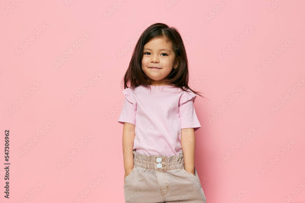 a cute, funny girl stands in stylish clothes holding her hands in her pockets and looks into the camera. She has a pink streak in her hair. Photography with empty space for advertising mockup insert a cute, funny girl stands in stylish clothes holding her hands in her pockets and looks into the camera. She has a pink streak in her hair. Photography with empty space for advertising mockup insert