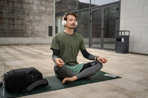 one man doing guided meditation online yoga self care concept outdoor © Miljan Živković
