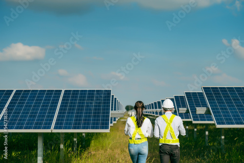 Asian Young Inspector Engineer man and female walking checking operation in solar farm