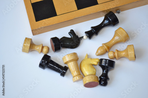 Scattered chess pieces and a chessboard