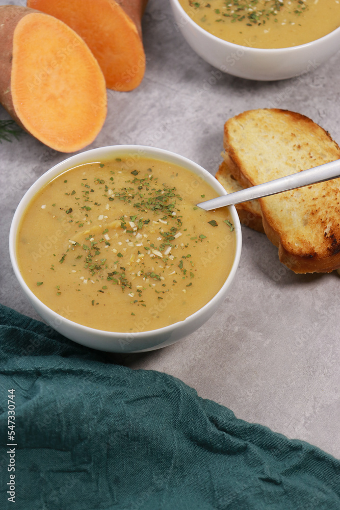 sweet potato puree soup with garlic bread on grey marble table sweet potato puree soup with garlic bread on grey marble table