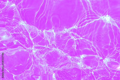 Defocus blurred transparent purple colored clear calm water surface texture with splashes and bubbles. Trendy abstract nature background. Water waves in sunlight with copy space. Pink watercolor shine