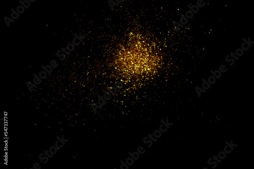 Gold glitter powder sparkling on black background.texture christmas
