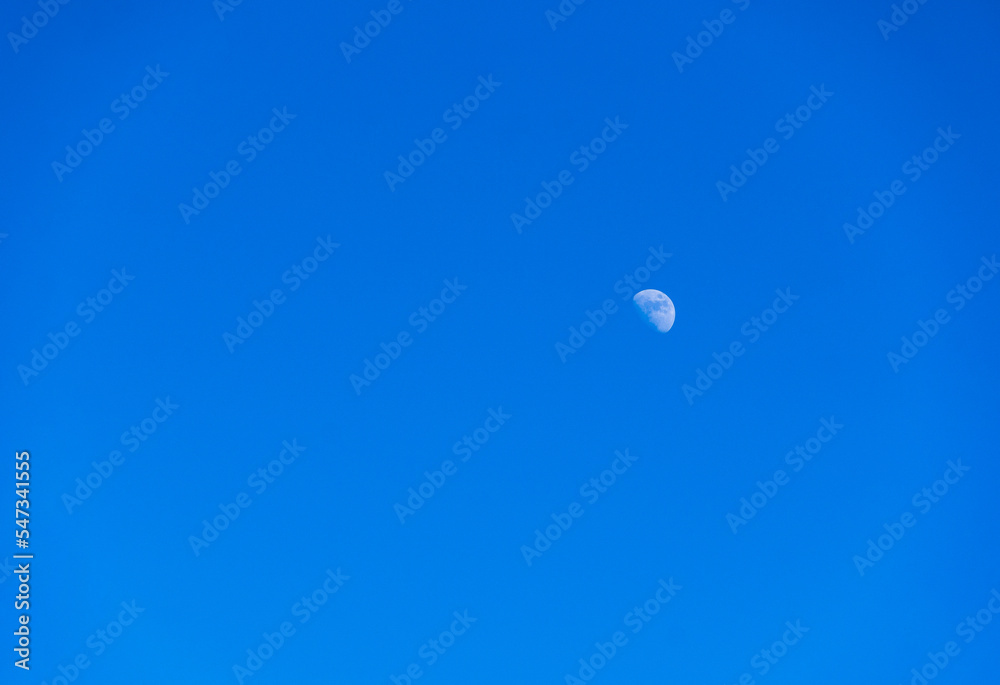The dark blue sky during the day without clouds clearly revealing the moon It is a beautiful natural phenomenon. The dark blue sky during the day without clouds clearly revealing the moon It is a beautiful natural phenomenon.