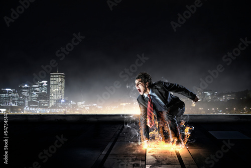 Fotografie Determined businessman leaving fire trails on asphalt