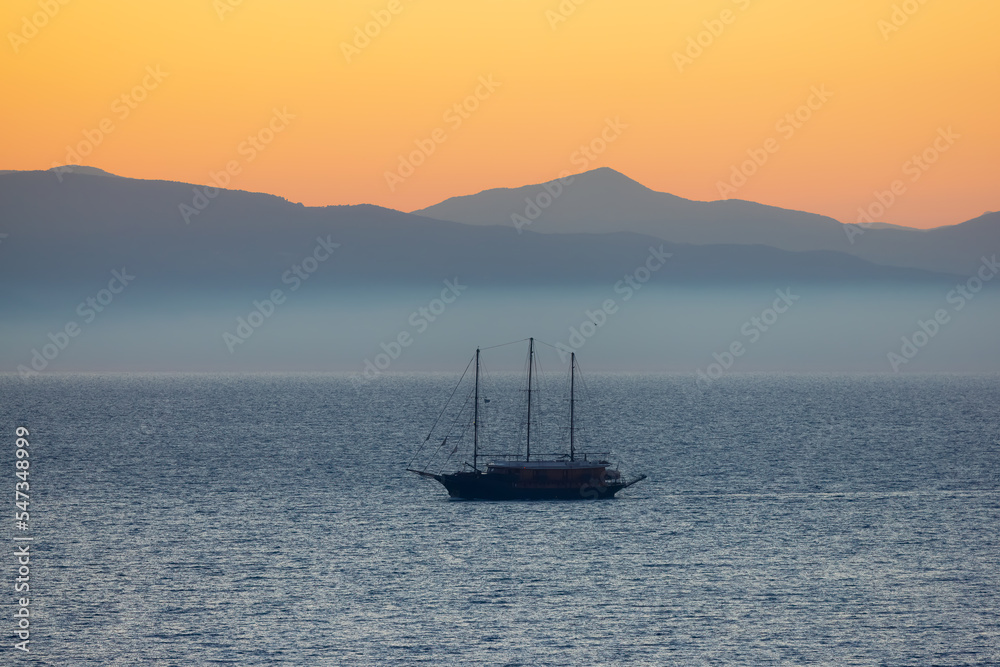 Sailboat in the Ionian Sea with Mountain Landscape Background. Twilight Sunrise Sky. Katakolo, Greece.