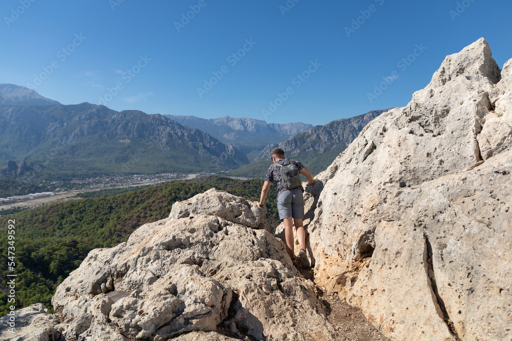 The man on a mountaintop admiring the surrounding mountain landscape The man on a mountaintop admiring the surrounding mountain landscape