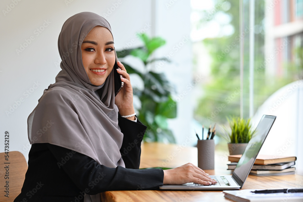 Young Arabian businesswoman talking with partner or customer with smartphone. Young Arabian businesswoman talking with partner or customer with smartphone.
