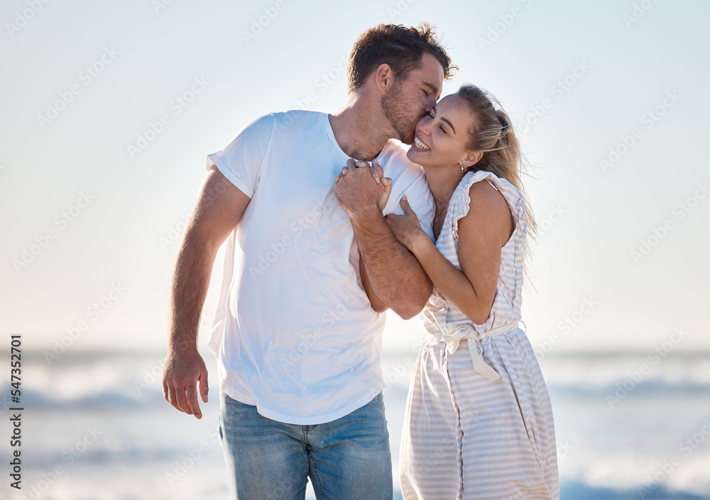 Happy, love and couple at the beach while on a vacation for romance, honeymoon or relaxation. Happiness, kiss and young man and woman walking by the ocean while on romantic holiday adventure together Happy, love and couple at the beach while on a vacation for romance, honeymoon or relaxation. Happiness, kiss and young man and woman walking by the ocean while on romantic holiday adventure together