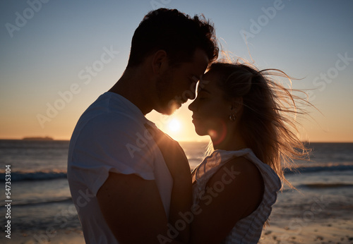 Sunset, silhouette and couple with love at the beach, affection and quality time on a holiday in Bali. Dark, sunrise and man and woman with care, hug and peace by the tropical water on vacation © D Theron/peopleimages.com
