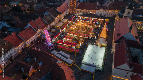 Landscape photography of Sibiu city center with the Christmas Fair, shot from a drone at sunset with the city lightning on. Birds eye view over cityscape of Sibiu, Romania.
