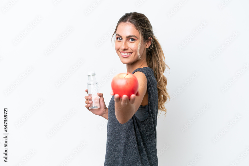 Young pretty Uruguayan woman isolated on white background with an apple and with a bottle of water Young pretty Uruguayan woman isolated on white background with an apple and with a bottle of water