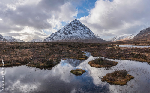 Majestic Winter landscape image of River Etive in foreground with iconic snowcapped Stob Dearg Buachaille Etive Mor mountain in the background photo