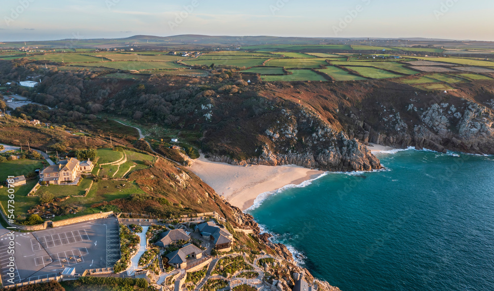 Aerial drone landscape image of Minnack Theatre headland around Porthcurno beach in Cornwall England at dawn