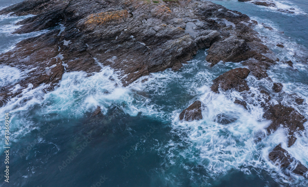 Beautiful aerial drone landscape image of Prussia Cove at sunrise in Cornwall England with atmospheric daramatic sky and clouds