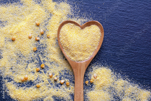 фотографія Yellow cornmeal in heart-shaped spoon