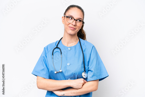Young caucasian surgeon doctor woman isolated on white background with arms crossed and happy