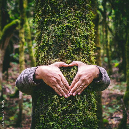 One man hugging a green tree trunk doing heart gesture with hands. People and love respect for nature forest and environment lifestyle. Environmentalist embrace trunk with musk. Stop climate change #547366947