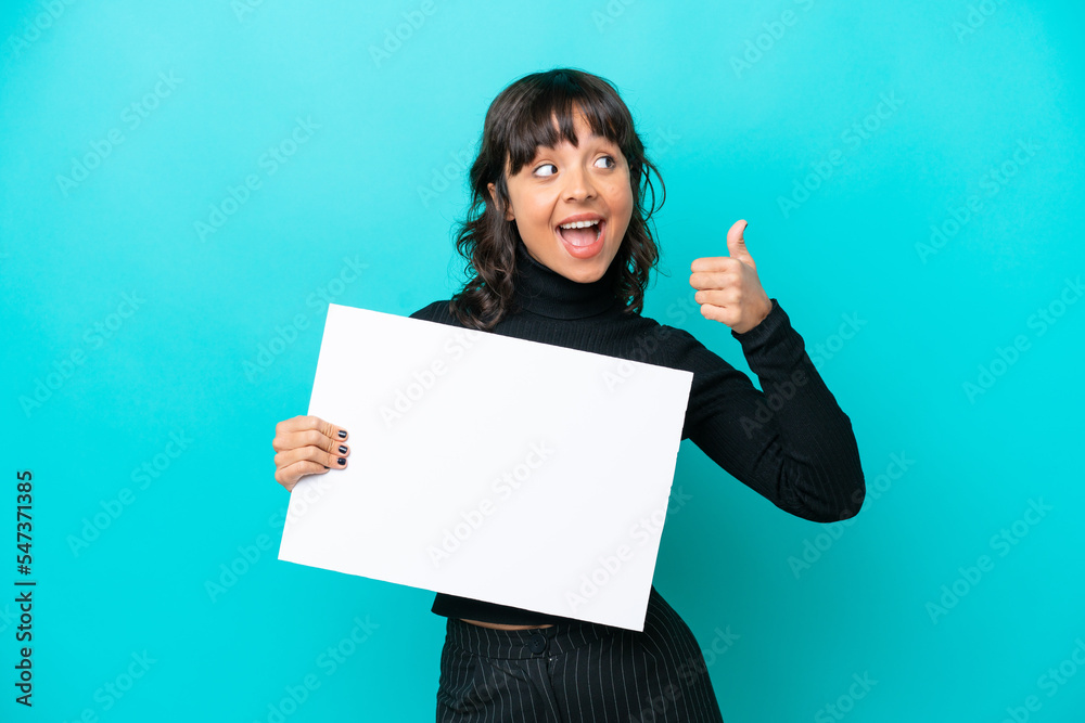 Young latin woman isolated on blue background holding an empty placard and pointing side Young latin woman isolated on blue background holding an empty placard and pointing side