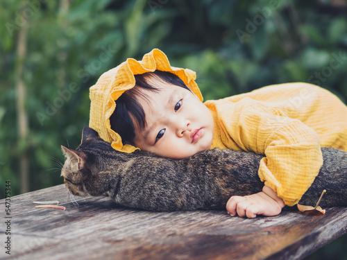 Asian baby of Thai nationality and cat at De mala Cafe, Thung Saliam, Sukhothai, Thailand.