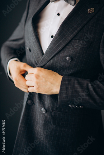 A man in a blue suit zips up his jacket, close-up. Businessman changing clothes.Tonal correction. FASHION, STYLE