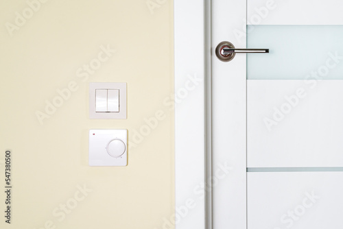 Underfloor heating thermostat panel on the wall next to the door,setting temperature on underfloor heating control panel