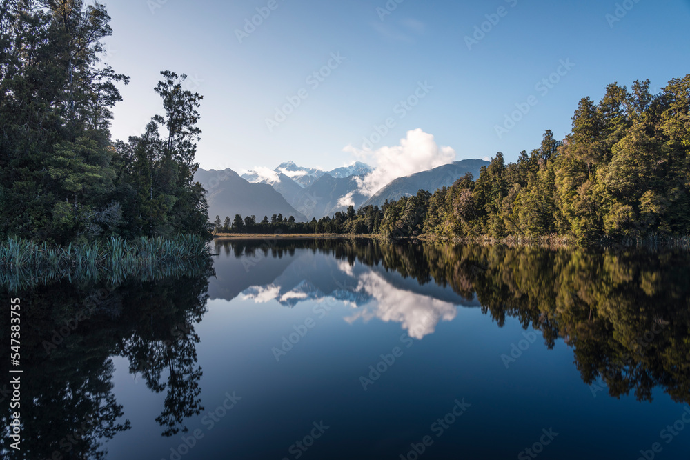 Spiegelsee an der Küste Neuseelands mit den Alpen und Gletschern im Hintergrund.