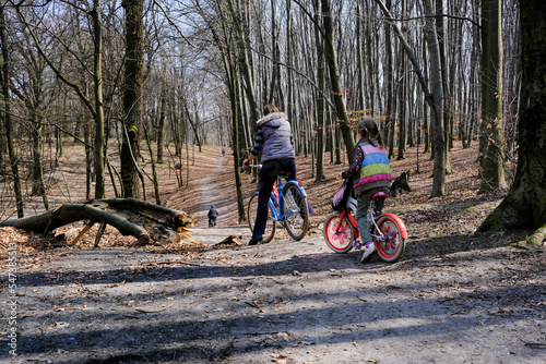 A family riding bikes in a Spring forest at Holosiivskyi National Nature Park, Kyiv, Ukraine photo