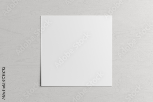 Square sheet of paper on the white wooden table.