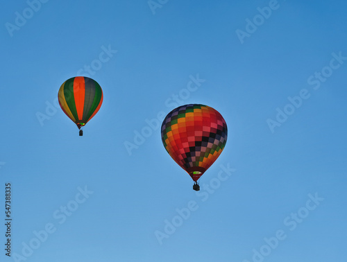 Two colorful hot air balloons flying through the sky.