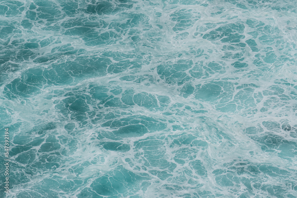 Obraz premium The waves of the ocean water meet with underwater pointed rocks
