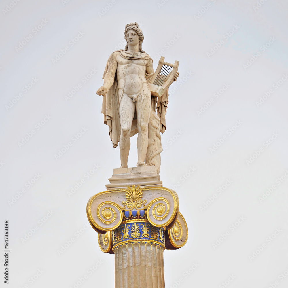 Apollo's marble statue, the ancient Greek god of Arts, on a Corinthian rhythm column capital. Cultural travel in Athens, Greece.