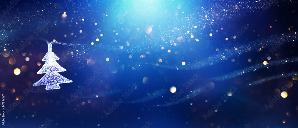 Fototapeta premium Christmas tree garland lights over dark background with glitter overlay