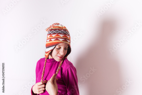 Little girl wearing a wool hat smiling and looking down