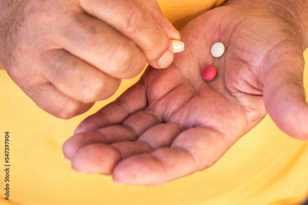 Close up view of senior woman holding vitamins and minerals pills in hand Close up view of senior woman holding vitamins and minerals pills in hand