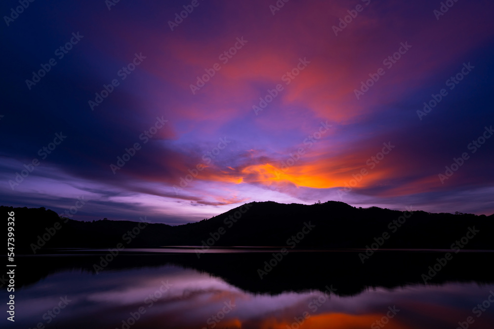 Sunset or sunrise sky clouds over mountains,Beautiful reflex sunset or sunrise light in water surface,Amazing nature landscape Colorful sky clouds background