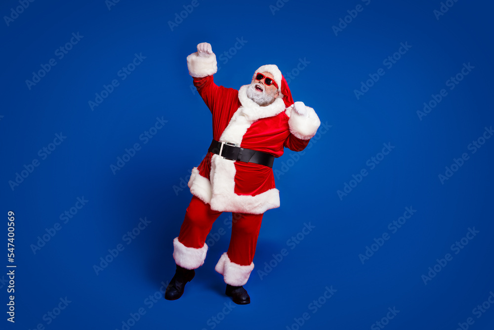 Full length body size view of attractive cheerful Santa dancing rejoicing newyear occasion isolated over bright red color background Full length body size view of attractive cheerful Santa dancing rejoicing newyear occasion isolated over bright red color background