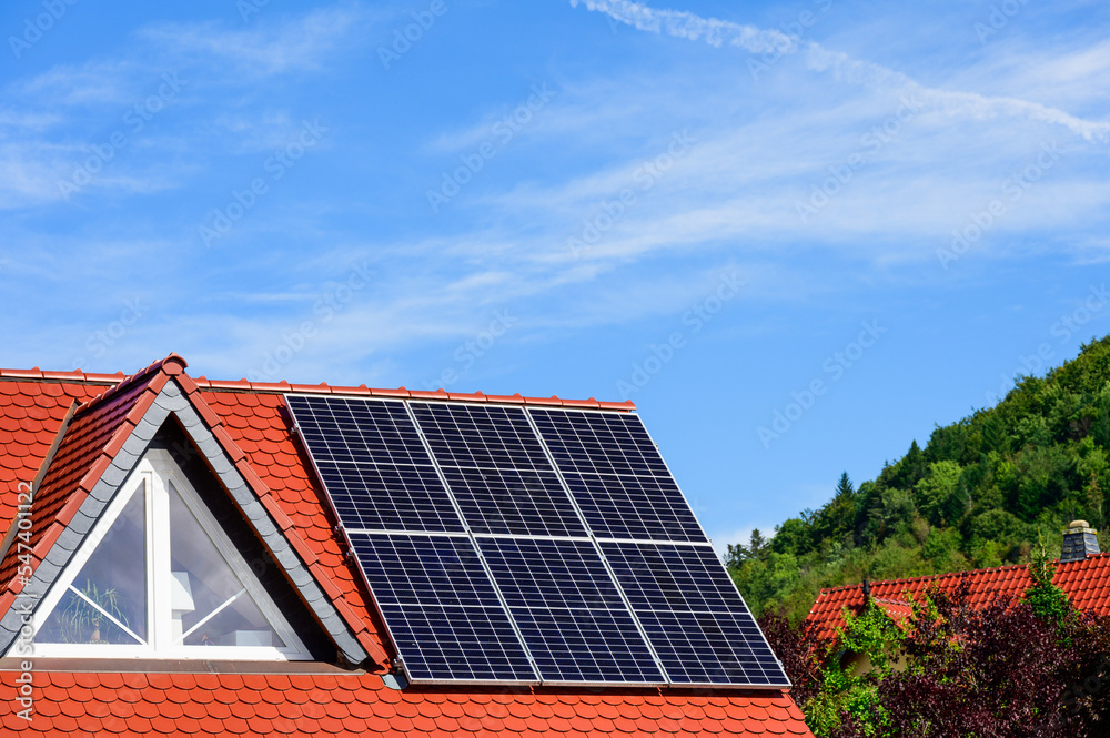 Solaranlage auf modernem, rotem Hausdach mit Dreiecksgiebel Solaranlage auf modernem, rotem Hausdach mit Dreiecksgiebel