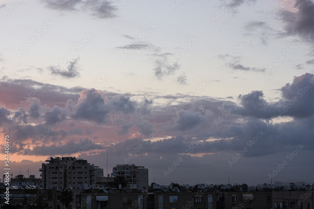Sunset over the city. View of the city against of  fluffy clouds. Background. Israel.

