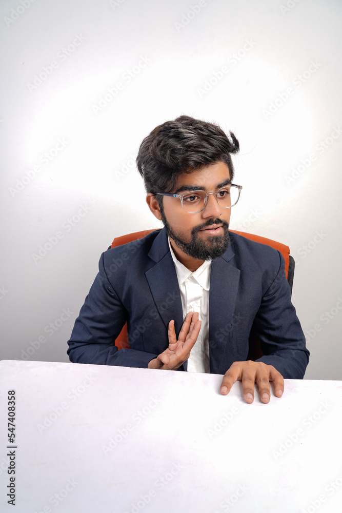 indian young business man on chair table talking to someone or explaining something to someone indian young business man on chair table talking to someone or explaining something to someone