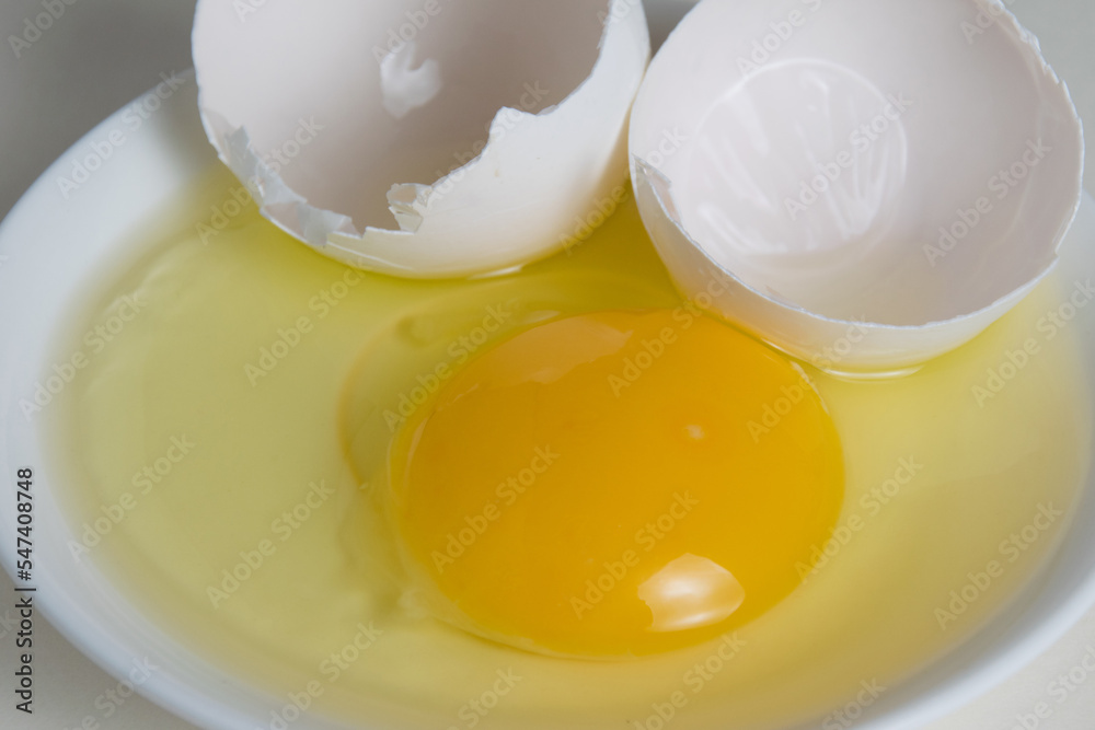 Egg yolk and shell on a plate isolate on a white background Egg yolk and shell on a plate isolate on a white background