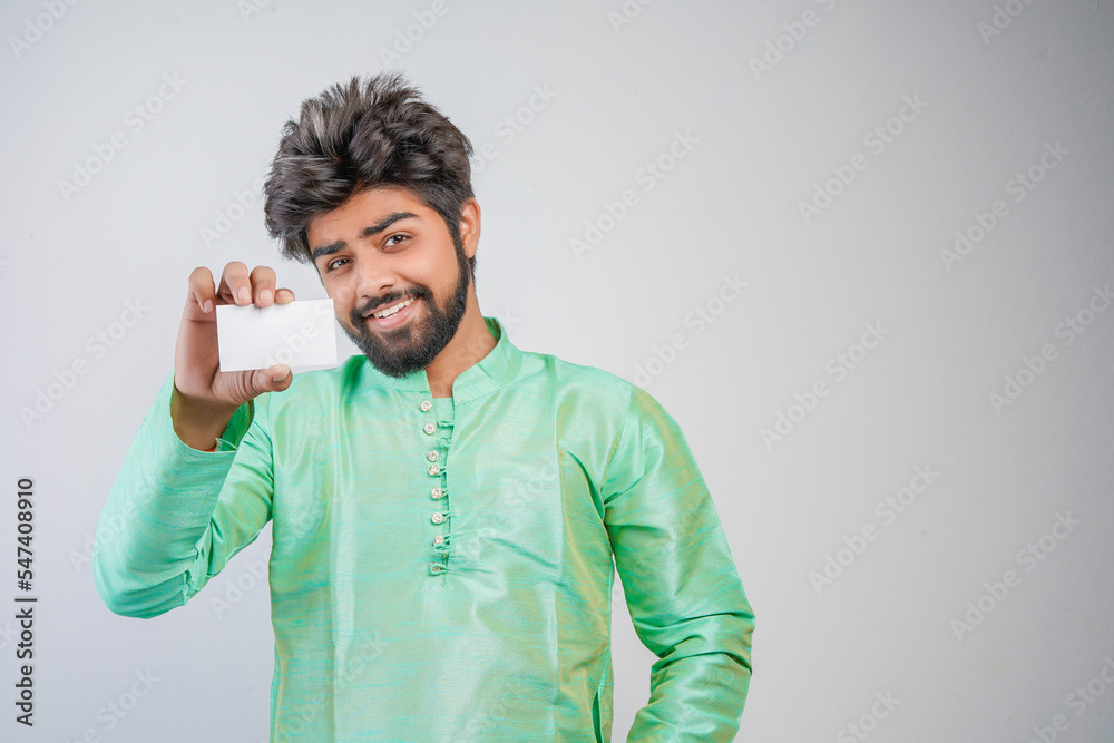Young indian man wearing traditional and showing card on white background Young indian man wearing traditional and showing card on white background