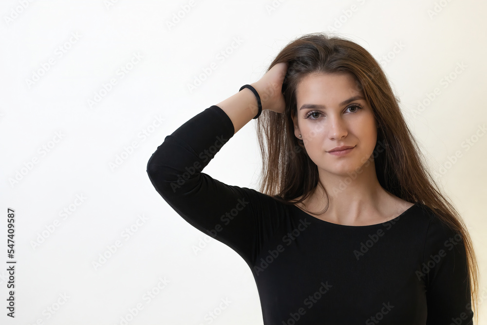 Portrait of smiling attractive girl posing with hand in her hair.Horizontally. Portrait of smiling attractive girl posing with hand in her hair.Horizontally.