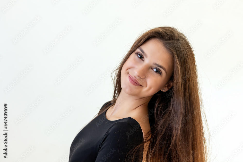 Smiling attractive girl is posing on the light background. Horizontally. Smiling attractive girl is posing on the light background. Horizontally.